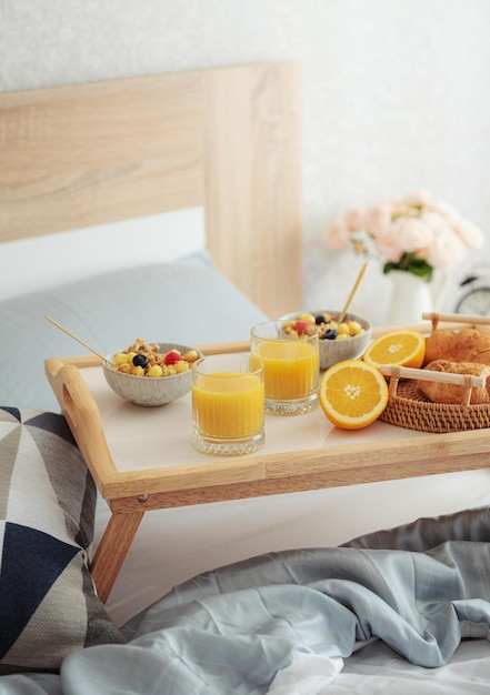 Petit-déjeuner romantique avec café, gaufres, jus d'orange et fleurs de rose.