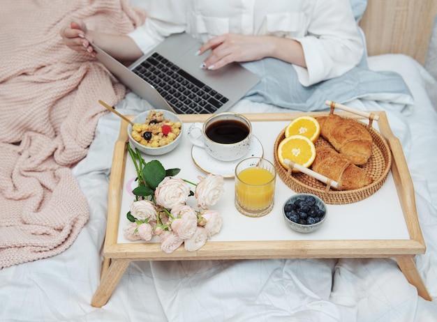 Petit-déjeuner romantique avec café, gaufres, jus d'orange et fleurs de rose.