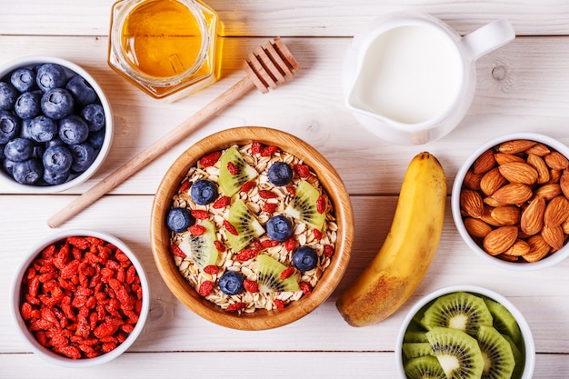 Petit-déjeuner sain - bol de flocons d'avoine avec fruits frais, amande et miel