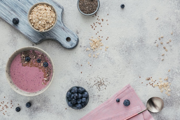 Petit-déjeuner sain avec bol de smoothie au yogourt rose à base de baies et de graines