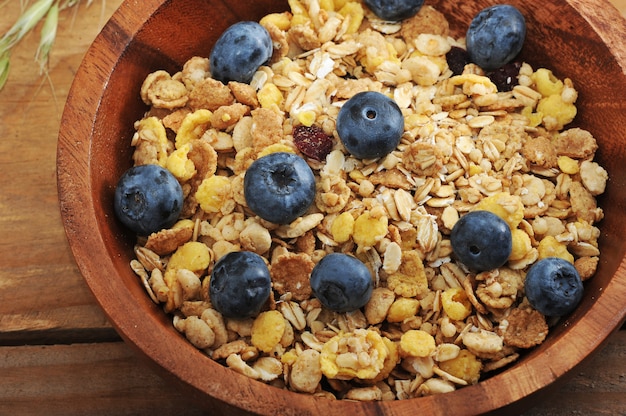 Petit déjeuner sain avec des céréales aux bleuets dans un bol en bois