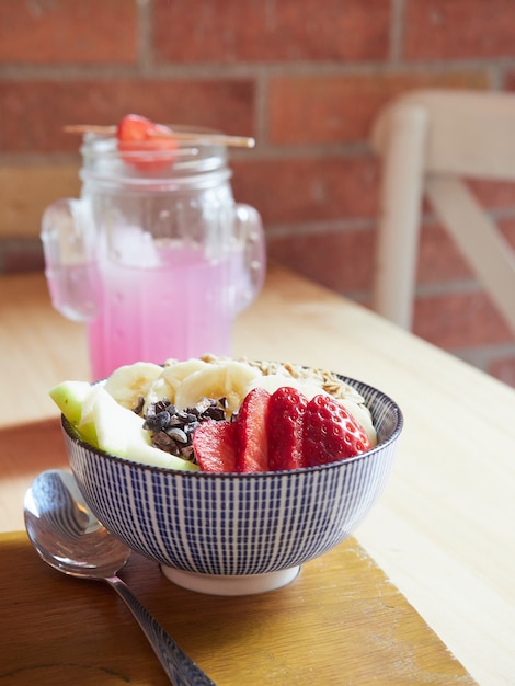 Petit-déjeuner sain dans une cafétéria, bol de salade de fruits et limonade rose