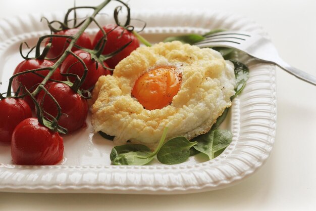 Petit-déjeuner sain avec des épinards aux œufs en nuage et des tomates cerises Les nuages de sont un plat à four