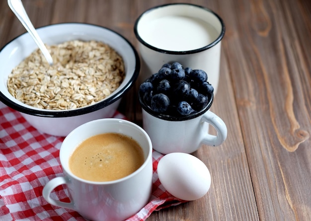 Un petit-déjeuner sain est un bon début pour une nouvelle journée Bouillie d'avoine baies de café et noix sur une table en bois