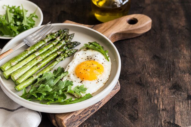 Petit déjeuner sain et fait maison avec asperges, œuf au plat et roquette. concept de saine alimentation de quarantaine. régime céto