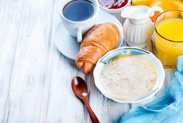 Petit-déjeuner sain avec des flocons d&#39;avoine avec du beurre, des croissants et du café