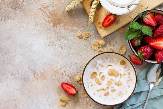 Petit-déjeuner sain flocons de grains entiers lait et fraises fraîches sur fond de pierre ou d'ardoise