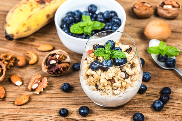 Petit-déjeuner sain: granola d&#39;avoine au yogourt et myrtilles fraîches sur fond de bois