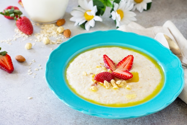 Petit-déjeuner sain en gros plan Bouillie de flocons d'avoine avec noix et fraises fraîches Copy space