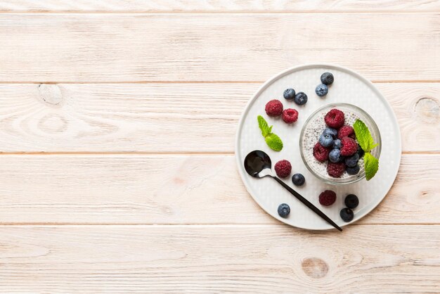 Petit-déjeuner sain ou matin avec des graines de chia pudding à la vanille framboises et myrtilles baies sur fond de table régime alimentaire végétarien et concept de santé Pudding de chia aux framboises et myrtilles