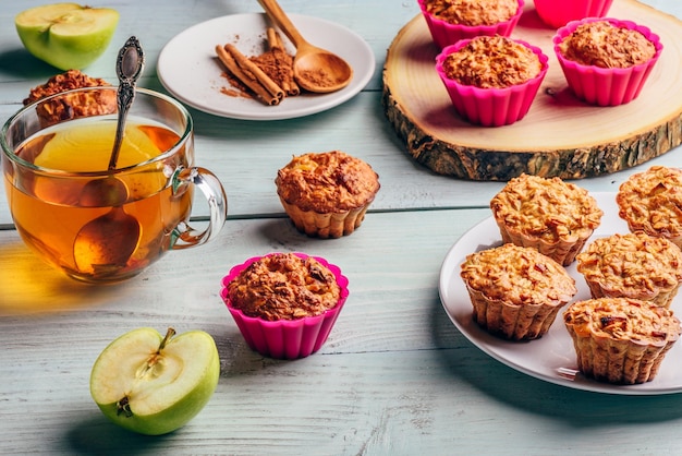 Petit déjeuner sain Muffins d'avoine cuits avec pomme et une tasse de thé vert sur un fond en bois clair