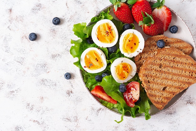 Petit-déjeuner sain Toast avec fraise et œuf Alimentation saine et équilibrée Vue de dessus mise à plat