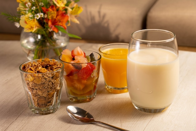 Petit-déjeuner sain avec yaourt, granola, fruits et jus d'orange.