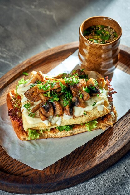 Petit-déjeuner sandwich avec Omelette et champignons et sauce blanche Fond de béton Lumière dure Nourriture végétarienne Gros plan