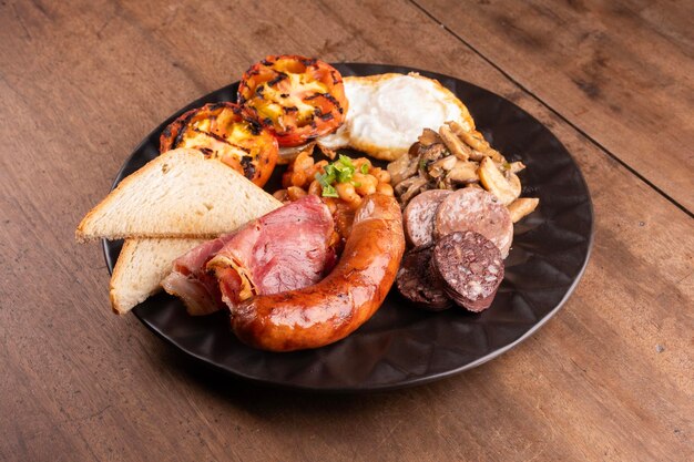 petit déjeuner savoureux anglais irlandais britanniques beaucoup de protéines haricots douces saucisses bacon œufs champignons table en bois de près