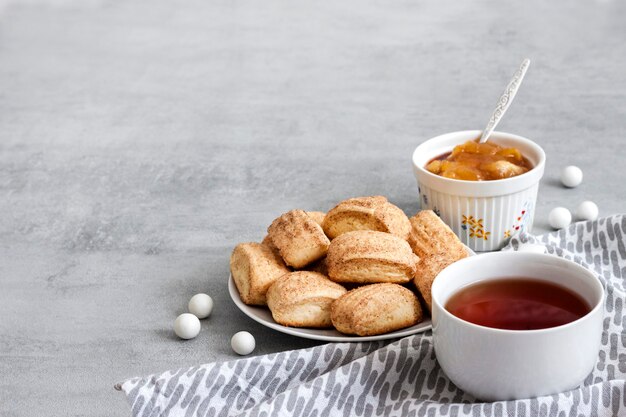 Petit déjeuner savoureux. Biscuits à la cannelle sucrés faits maison et tasse de thé. Confiture de pomme sur fond. Copier l'espace