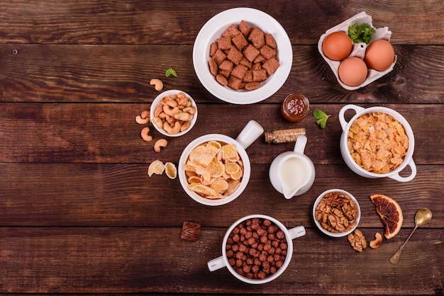 Petit déjeuner savoureux et utile avec des flocons, du lait, des noix et des fruits secs