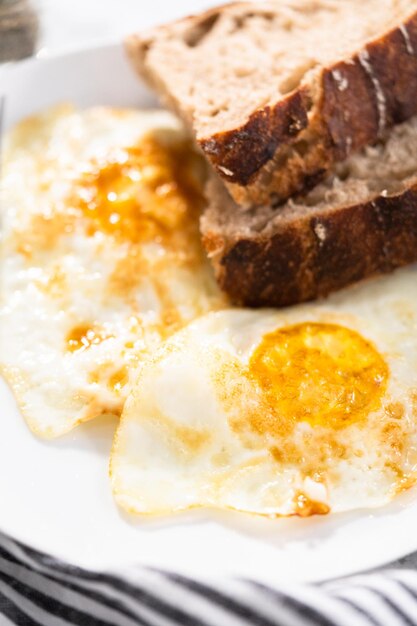 Petit-déjeuner simple avec des œufs sur du pain de blé facile et au levain.