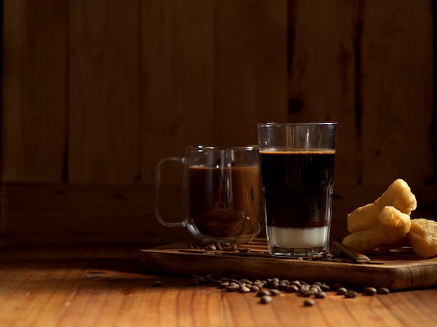 Petit-déjeuner de style thaïlandais avec verre et tasse de café et bâtonnets de pâte frits