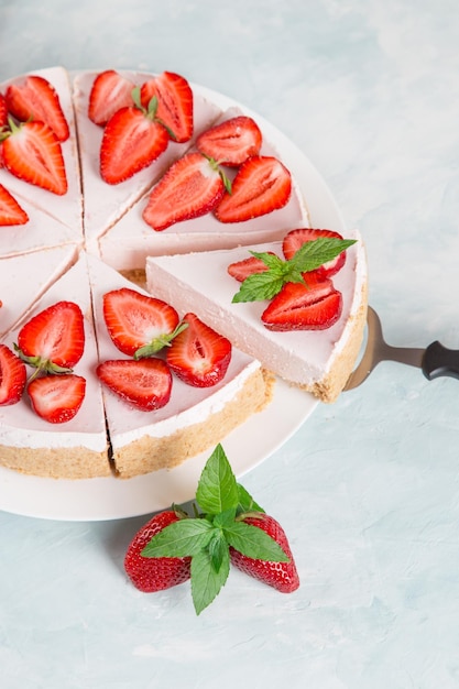 Petit-déjeuner sucré délicieux gâteau au fromage avec des fraises fraîches et une recette maison à la menthe sans cuisson sur une table en pierre bleue Copier l'espace