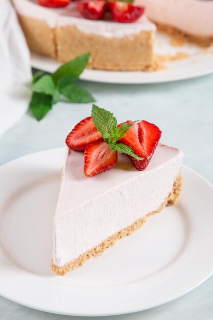 Petit-déjeuner sucré délicieux gâteau au fromage avec des fraises fraîches et une recette maison à la menthe sans cuisson sur une table en pierre bleue Copier l'espace