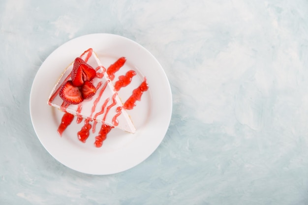 Petit-déjeuner sucré délicieux gâteau au fromage avec des fraises fraîches et une recette maison à la menthe sans cuisson sur une table en pierre bleue Copier l'espace