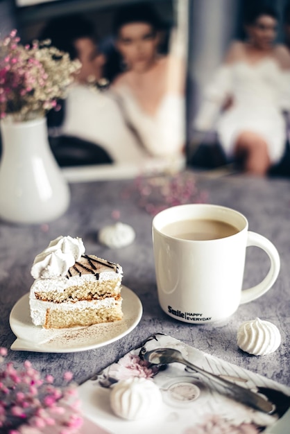 Petit-déjeuner sucré morceau de gâteau et une tasse de cappuccino sur fond gris un beau bonjour