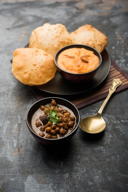 Petit-déjeuner Suji ou Sooji Halwa Puri ou Sheera ou Shira Poori, servi dans une assiette et un bol. mise au point sélective