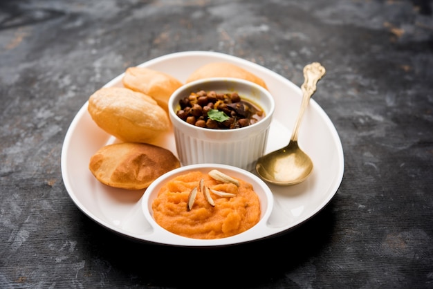 Petit-déjeuner Suji ou Sooji Halwa Puri ou Sheera ou Shira Poori, servi dans une assiette et un bol. mise au point sélective