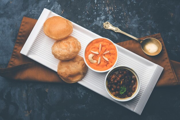 Petit-déjeuner Suji ou Sooji Halwa Puri ou Sheera ou Shira Poori, servi dans une assiette et un bol. mise au point sélective