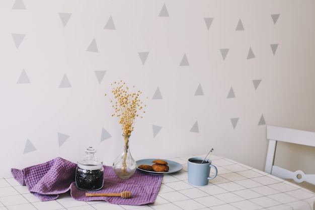 Petit déjeuner avec tasse de thé et biscuits sur la table