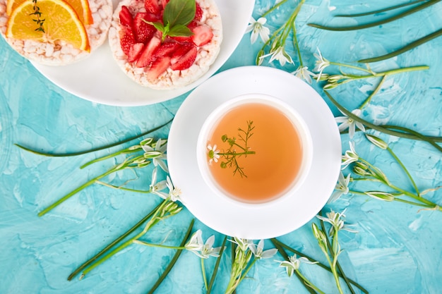 Photo petit déjeuner - thé, galette de riz aux fruits frais sur fond bleu.