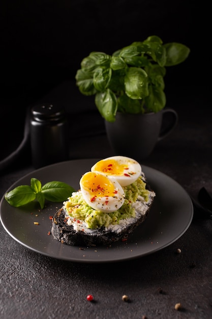 Petit-déjeuner avec toast à l'avocat avec des œufs sur une assiette