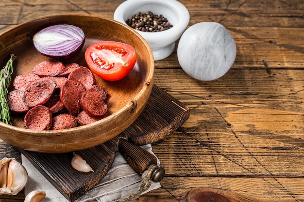 Petit-déjeuner turc avec sucuk de saucisses frites sur une assiette rustique. Fond en bois. Vue de dessus. Espace de copie.