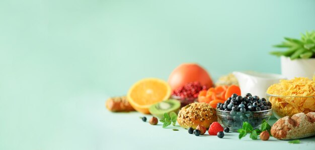 Photo petit-déjeuner végétarien oeuf à la coque flocons d'avoine noix fruits baies lait yogourt orange banane pêche sur fond bleu régime alimentaire sain copier l'espace bannière