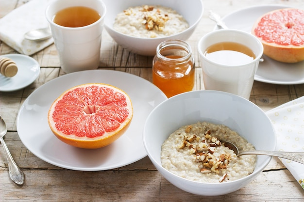 Petit-déjeuner végétarien pour deux composé de flocons d'avoine, de pamplemousses cuits et de thé