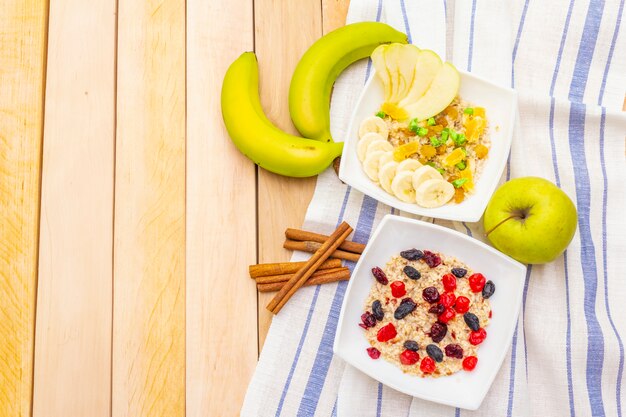 Petit-déjeuner végétarien sain (végétalien) avec flocons d'avoine et fruits. Table en bois