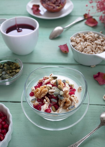 Petit-déjeuner avec yaourt, noix, céréales et graines de grenade. Petit-déjeuner sain