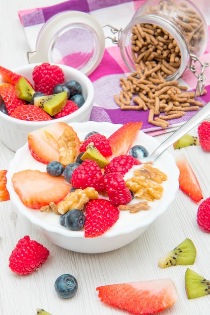 Petit-déjeuner avec yaourts, fruits et céréales