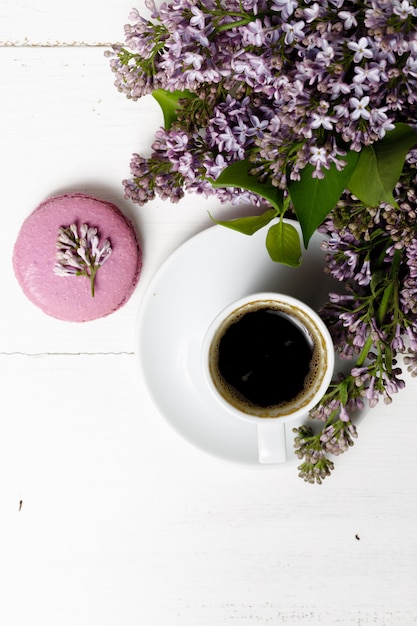Petit délicat bouquet élégant de fleurs de printemps et une tasse de thé sur une table en bois blanc, petit déjeuner le matin