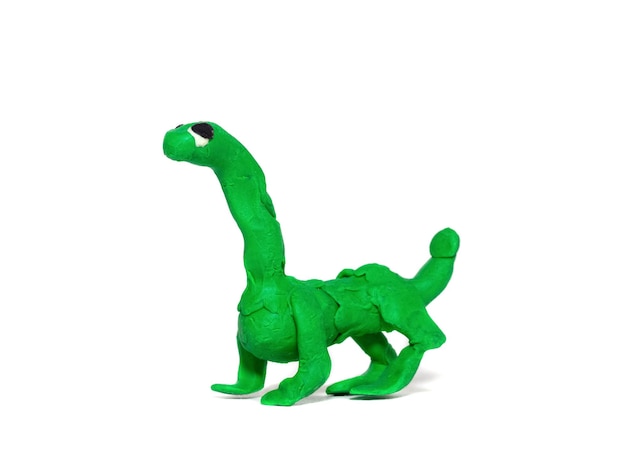 un petit dinosaure vert fait de pâte à modeler faite par un enfant