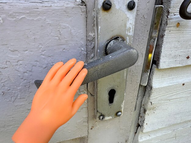 Photo petit doigt de marionnette tenant la poignée de la porte