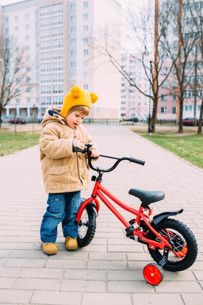 un petit enfant apprend à faire du vélo pour la première fois dans la ville au printemps