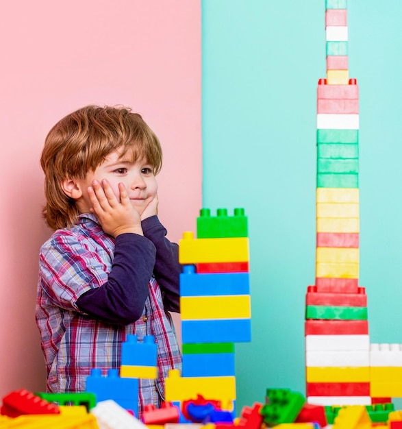 Photo un petit enfant apprend à plier un constructeur un garçon joue avec des blocs de construction à