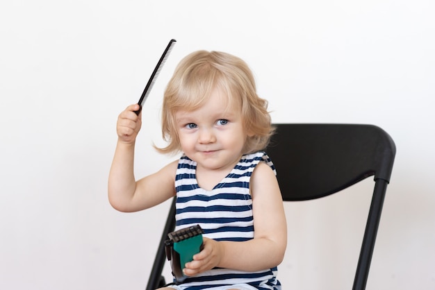 Un petit enfant apprend à se couper les cheveux et à se coiffer