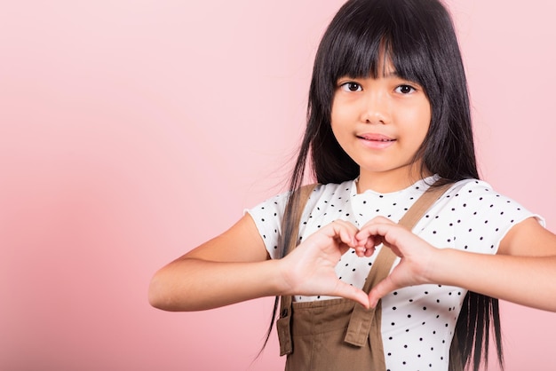 Petit enfant asiatique de 10 ans montrant un signe de coeur