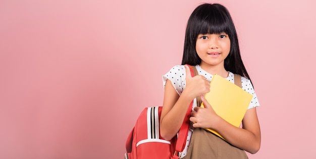 Un petit enfant asiatique de 10 ans avec sac à dos reste prêt pour la rentrée scolaire