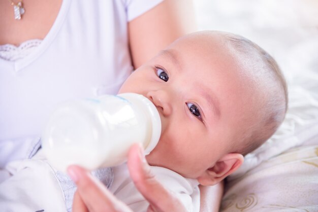 Petit enfant asiatique, boire du lait de bouteille