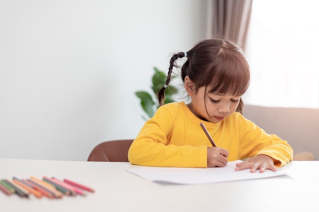 Petit enfant asiatique faisant ses devoirs à la maison