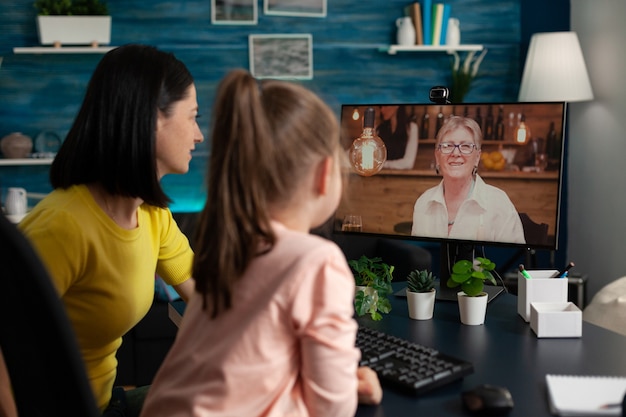 Petit enfant assis à côté d'un parent appréciant de discuter avec une grand-mère souriante